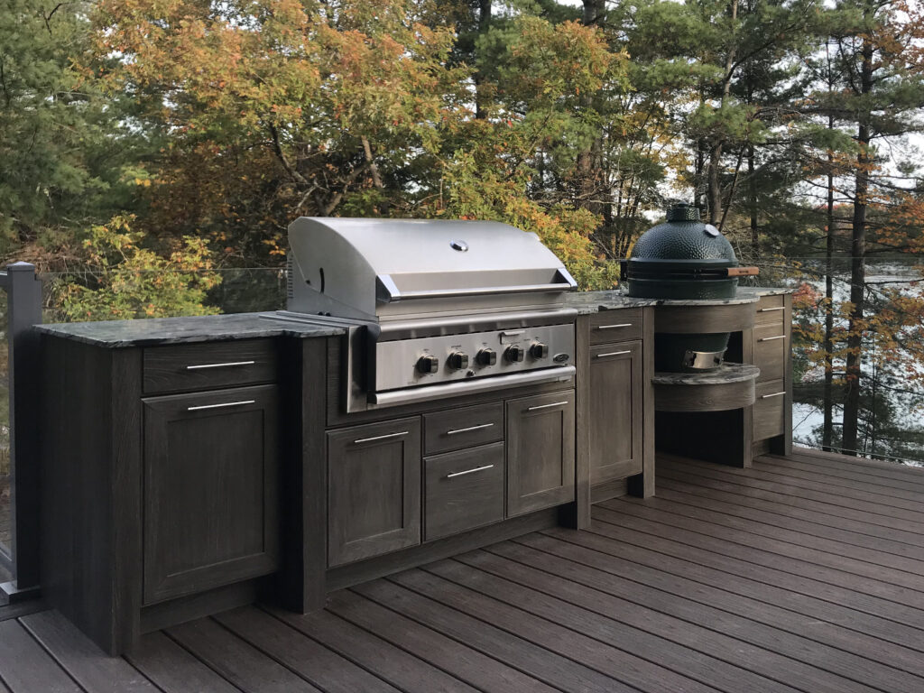 Outdoor cabinetry with grill on a lakeside deck by NatureKast